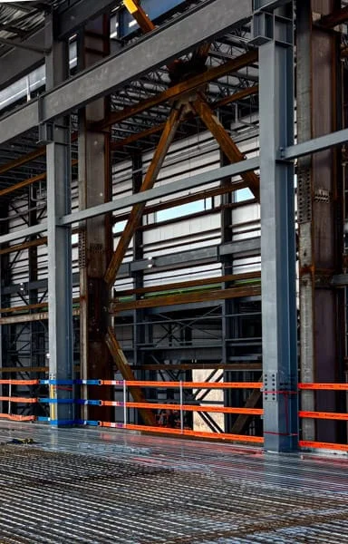 StrapRail installed for fall protection on the exposed edge in a large steel building.